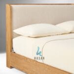 Detail sandaran wingback tempat tidur jati dengan tekstur kain premium